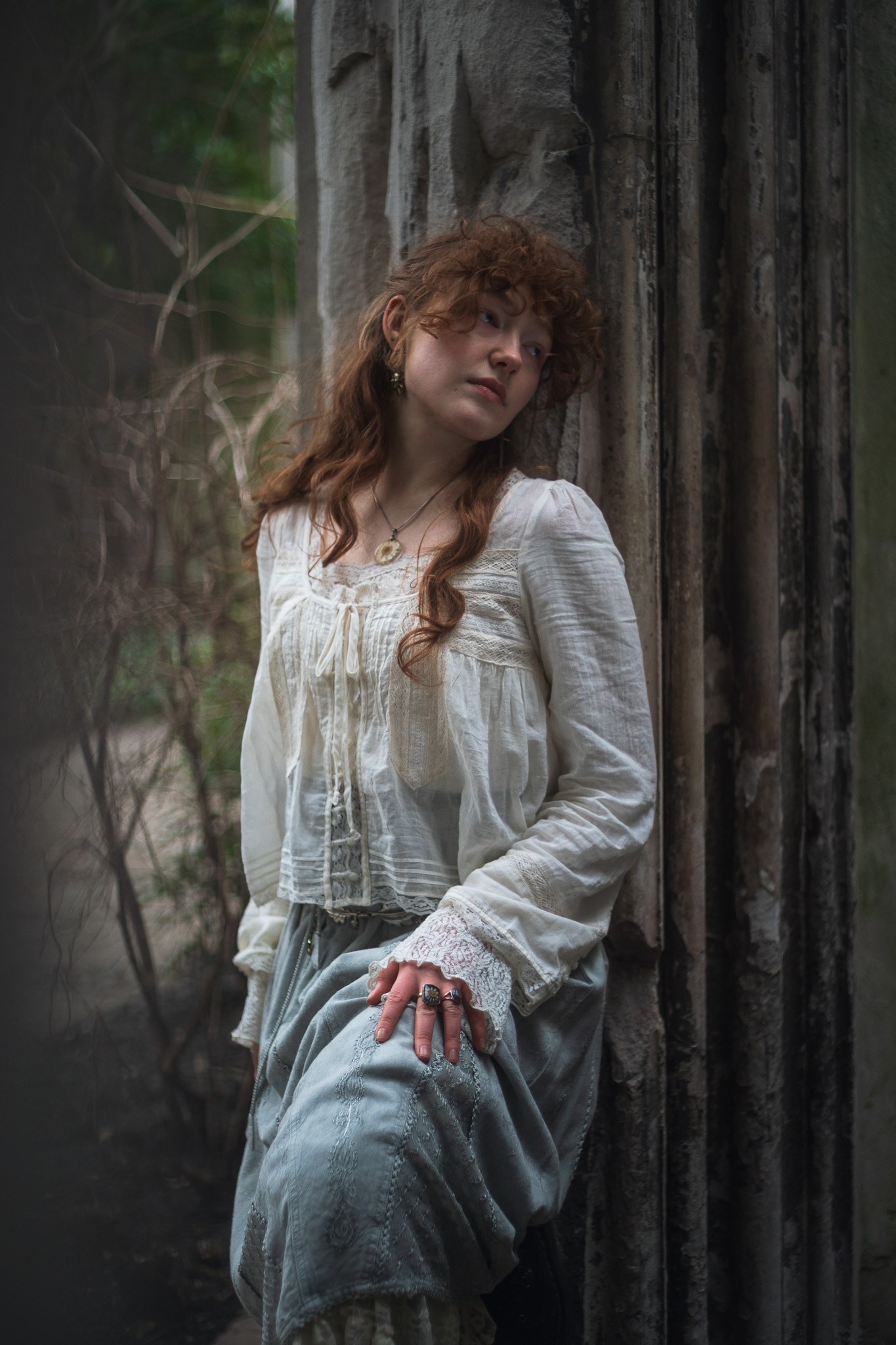 Outdoor portrait of a person with red hair beside weathered timber.